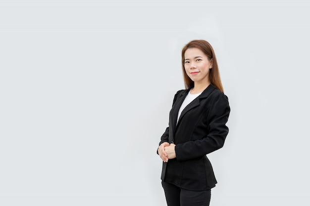 donna d'affari asiatici Mani incrociate in piedi con i capelli lunghi in abito nero isolato su colore bianco