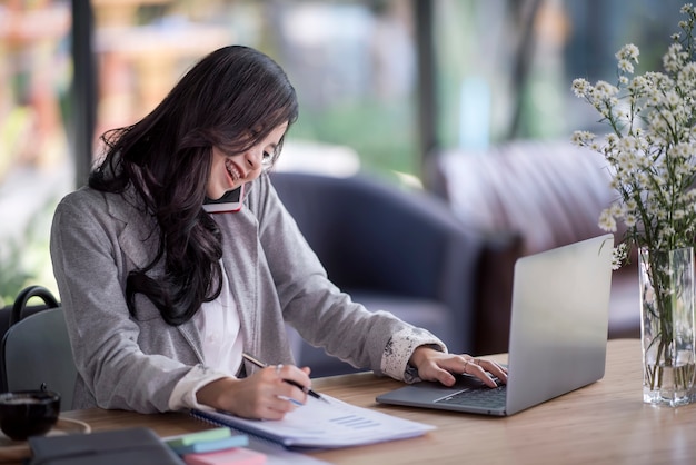 donna d&#39;affari asiatici oung lavorando dietro una scrivania