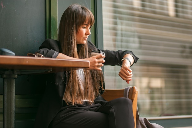 donna d'affari che beve caffè in un caffè