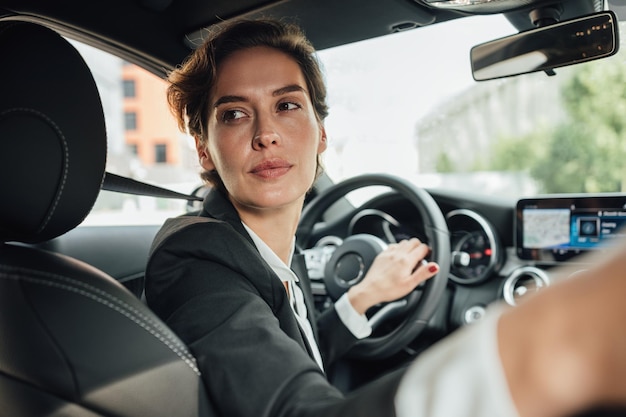Donna d'affari che guida un'auto