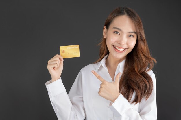 Donna d'affari che indossa una camicia bianca in piedi tenendo la carta di credito