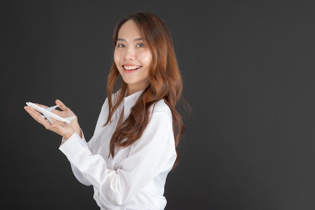 Donna d'affari che indossa una camicia bianca Mano che tiene un aereo giocattolo bianco