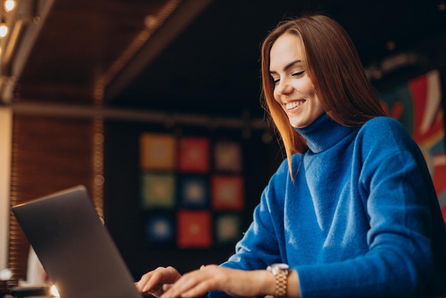 Donna d'affari che lavora al computer portatile in un bar