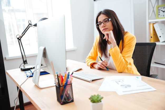 Donna d'affari che lavora al suo posto di lavoro in ufficio