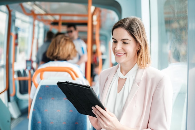 Donna d'affari che lavora con il tablet nei trasporti pubblici mentre va in ufficio per lavorare Concetto Imprenditore di affari treno