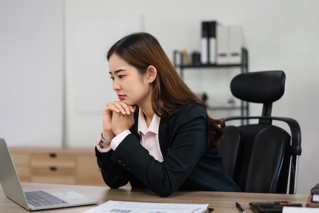 Donna d'affari che legge i dati finanziari sul laptop per pianificare il piano di marketing del nuovo progetto di avvio