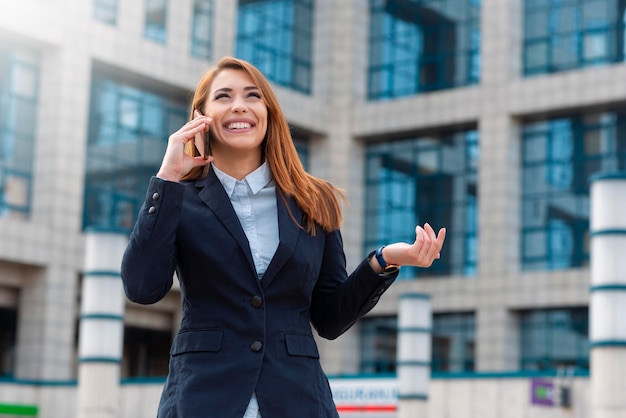 Donna d'affari che parla al telefono all'aperto