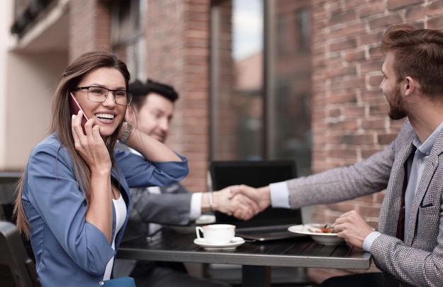 Donna d'affari che parla al telefono in un caffè di strada