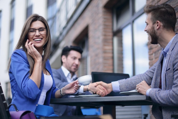 Donna d'affari che parla su smartphone nei giorni feriali di street cafeoffice