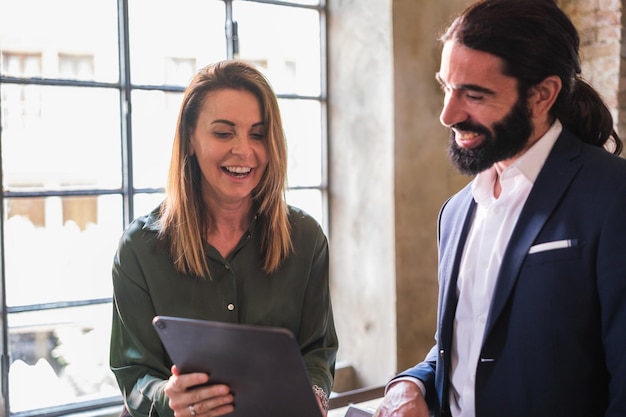 Donna d'affari che spiega il progetto di lavoro al suo partner con dispositivi elettronici