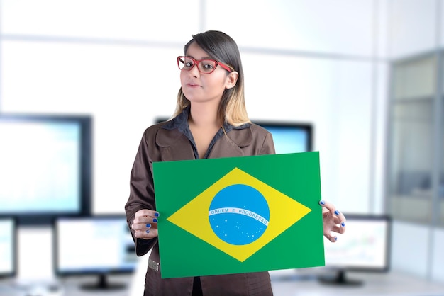 Donna d'affari che tiene la bandiera brasiliana