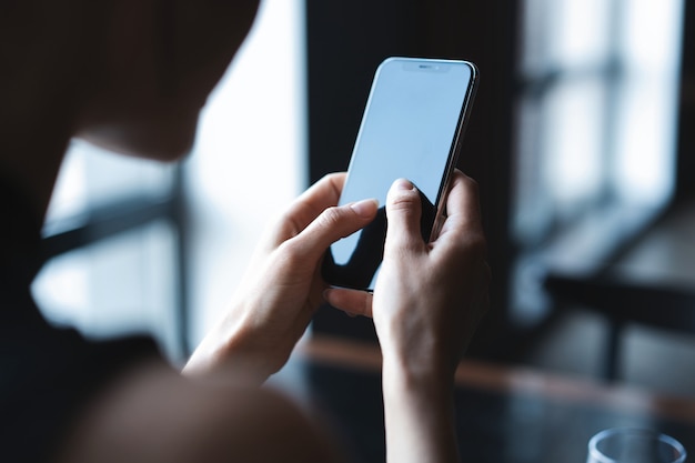 Donna d'affari che utilizza smartphone durante il pranzo nella caffetteria.