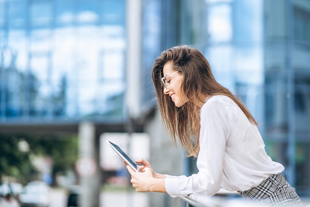 Donna d'affari che utilizza tablet vicino al moderno business center