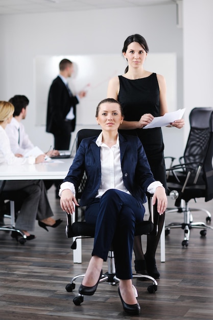 donna d'affari con il suo staff, gruppo di persone in background in un moderno ufficio luminoso al chiuso