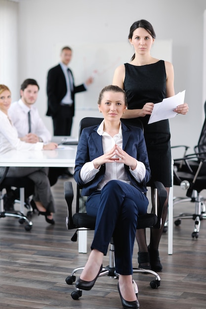 donna d'affari con il suo staff, gruppo di persone in background in un moderno ufficio luminoso al chiuso