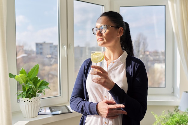 Donna d'affari con un bicchiere d'acqua con il limone