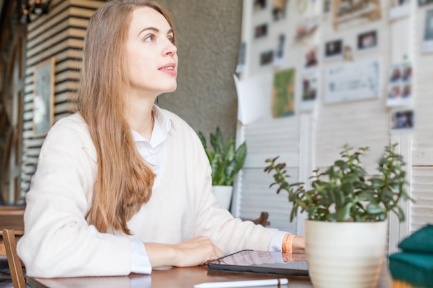 Donna d'affari creativa con gadget per laptop che lavora in ufficio