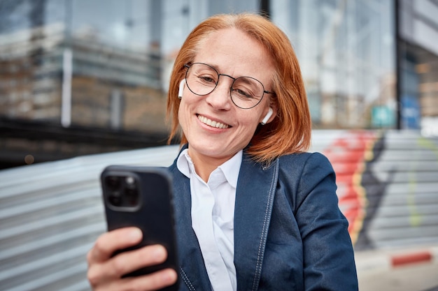 Donna d'affari di mezza età multitasking che trova il suo ritmo nel mondo degli affari urbani