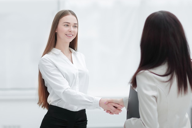 Donna d'affari di successo che stringe la mano al dipendente.