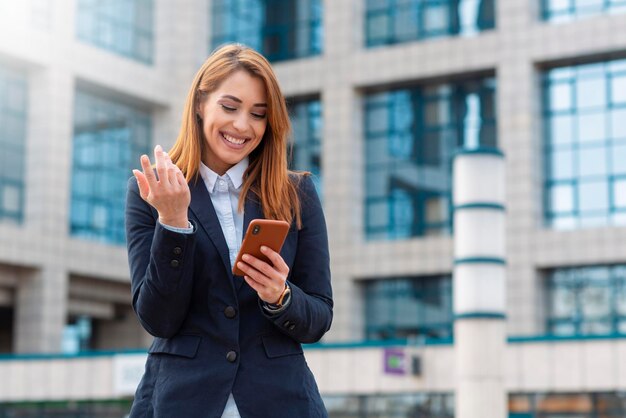 Donna d'affari di successo che tiene il suo telefono e legge un testo