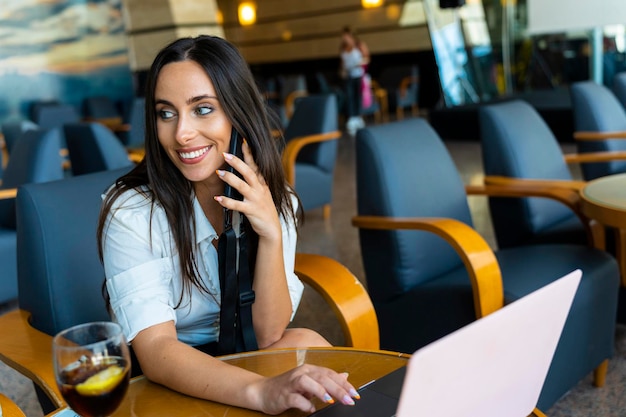 Donna d'affari durante una telefonata mentre aspetta il prossimo volo