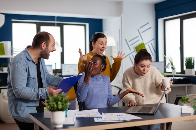 donna d'affari e il suo team che celebrano i risultati del lavoro in ufficio aziendale