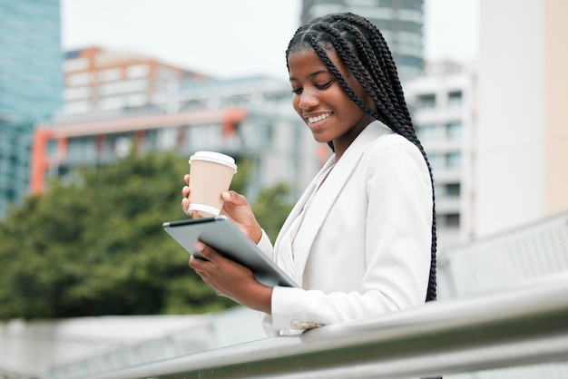 Donna d'affari e tablet con caffè in città durante l'utilizzo di Internet 5g per la ricerca online sui social media Donna d'affari pausa caffè e ricerca sui social network in una città urbana per la comunicazione