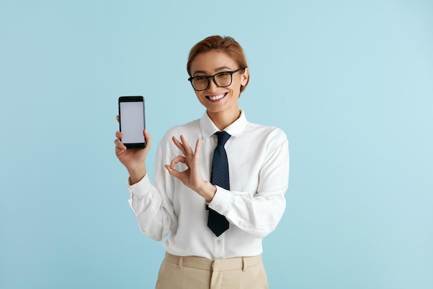 Donna d'affari felice che mostra l'app consigliata per la signora caucasica dello smartphone