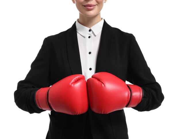 Donna d'affari in abito che indossa guanti da boxe su uno sfondo bianco