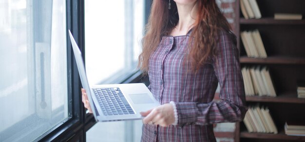 Donna d'affari in piedi con un computer portatile aperto