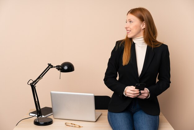 Donna d'affari in un ufficio guardando al lato