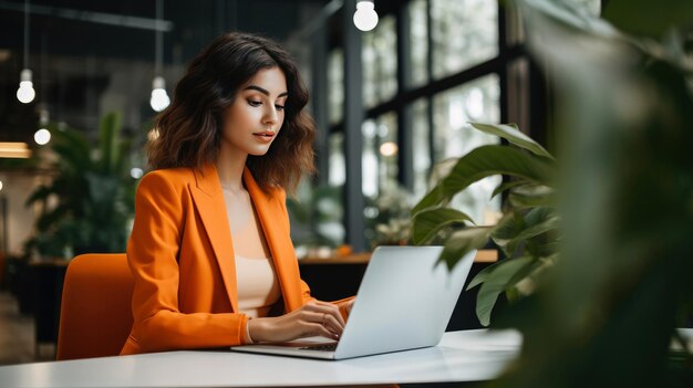 Donna d'affari latina che lavora su un computer portatile in un ufficio professionale