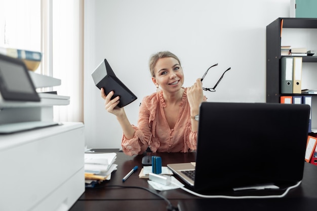 Donna d'affari lavoratore d'ufficio con calcolatrici al suo posto di lavoro in ufficio