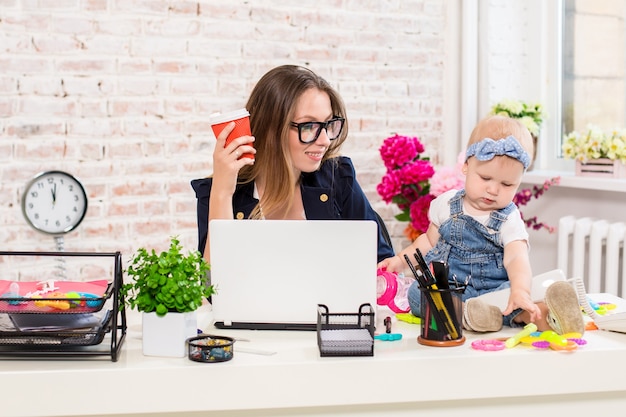 Donna d'affari madre donna con una figlia che lavora al computer