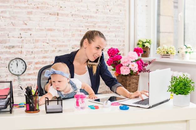 Donna d'affari madre donna con una figlia che lavora al laptop