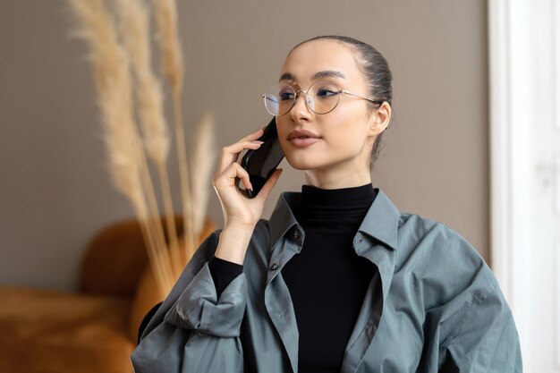 Donna d'affari negli occhiali dell'ufficio sul suo viso parlando al telefono