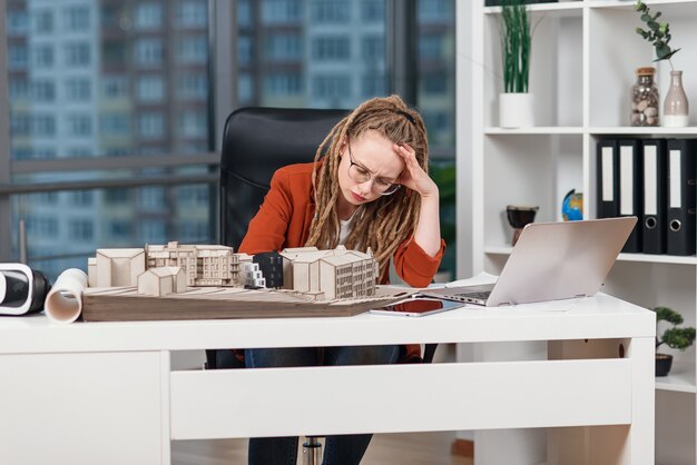 Donna d'affari oberati di lavoro che sente lo stress per alcuni problemi con il progetto architettonico e di design del futuro edificio.