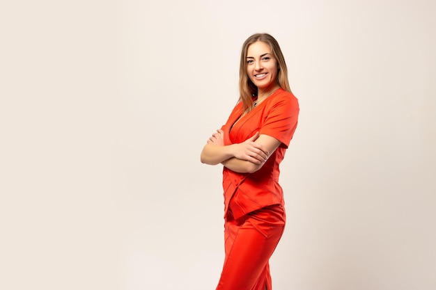 Donna d'affari positiva in un vestito rosso sorridente su sfondo bianco beige