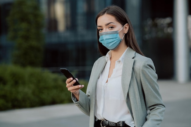 Donna d'affari segretaria d'ufficio vestita con camicia e giacca con una maschera protettiva sul viso