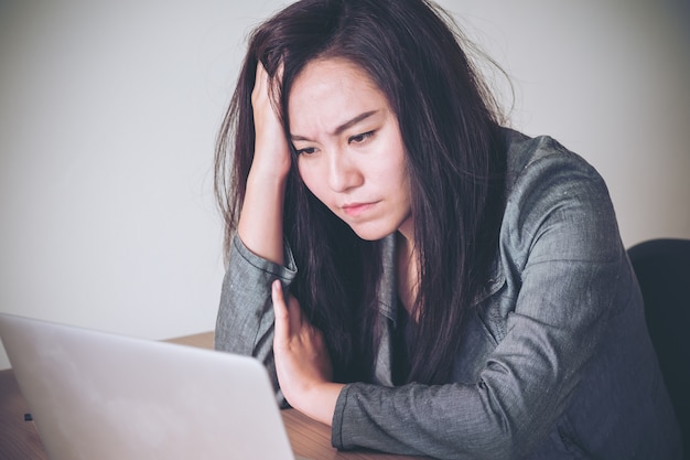 donna d&#39;affari si sentono stress quando si lavora sul computer portatile