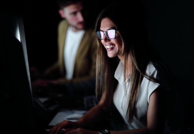 Donna d'affari sorridente ravvicinata che lavora su computerphoto su sfondo nero