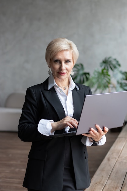 donna d'affari sta con il computer portatile in ufficio