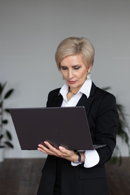 donna d'affari sta con il computer portatile in ufficio