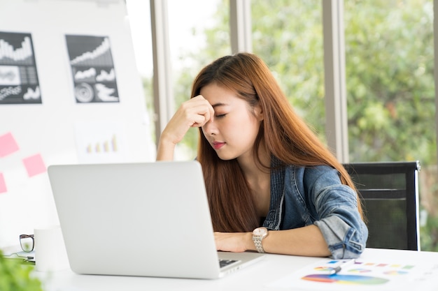 Donna d&#39;affari stanca dal lavoro in ufficio