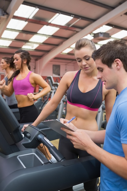 Donna d&#39;aiuto dell&#39;istruttore della palestra