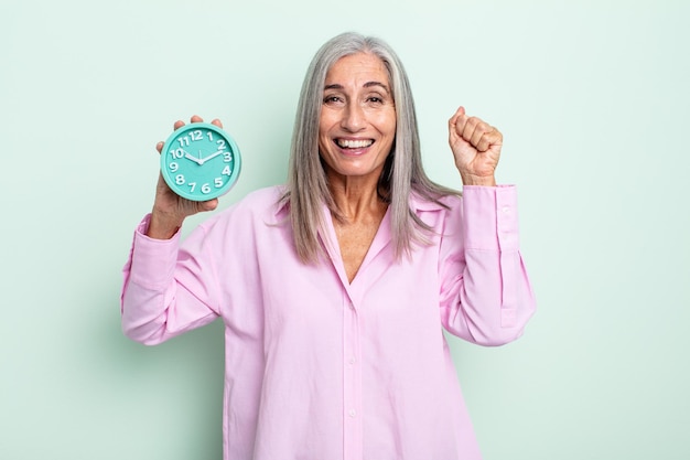 Donna dai capelli grigi di mezza età che si sente scioccata, ride e celebra il successo. concetto di sveglia