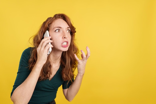 Donna dai capelli rossi arrabbiata che parla al cellulare