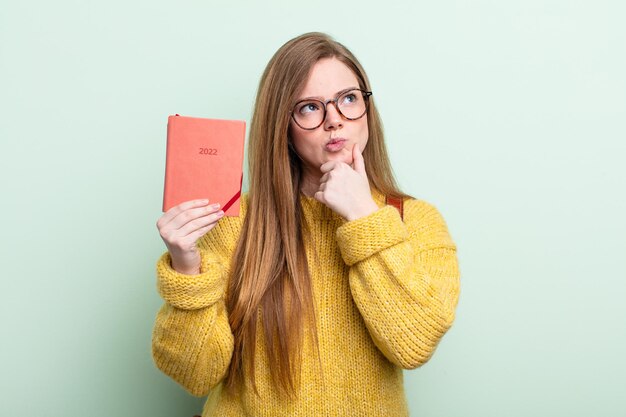 Donna dai capelli rossi che pensa, si sente dubbiosa e confusa concetto di pianificatore