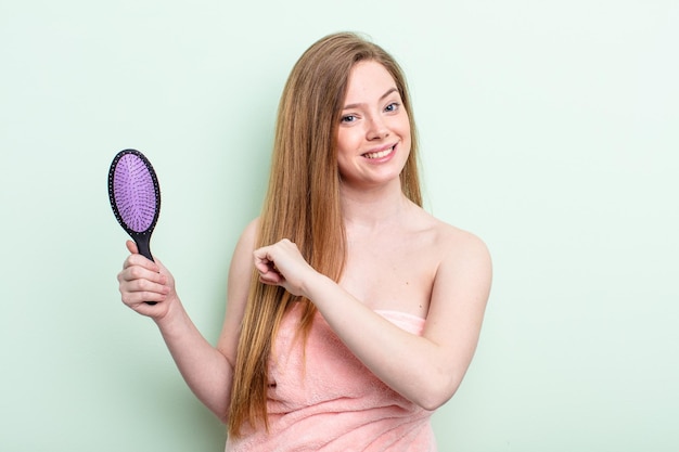 Donna dai capelli rossi che si sente felice e affronta una sfida o festeggia. concetto di pettine per capelli