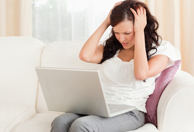 Donna dai capelli rossi con il computer portatile che è frustrato